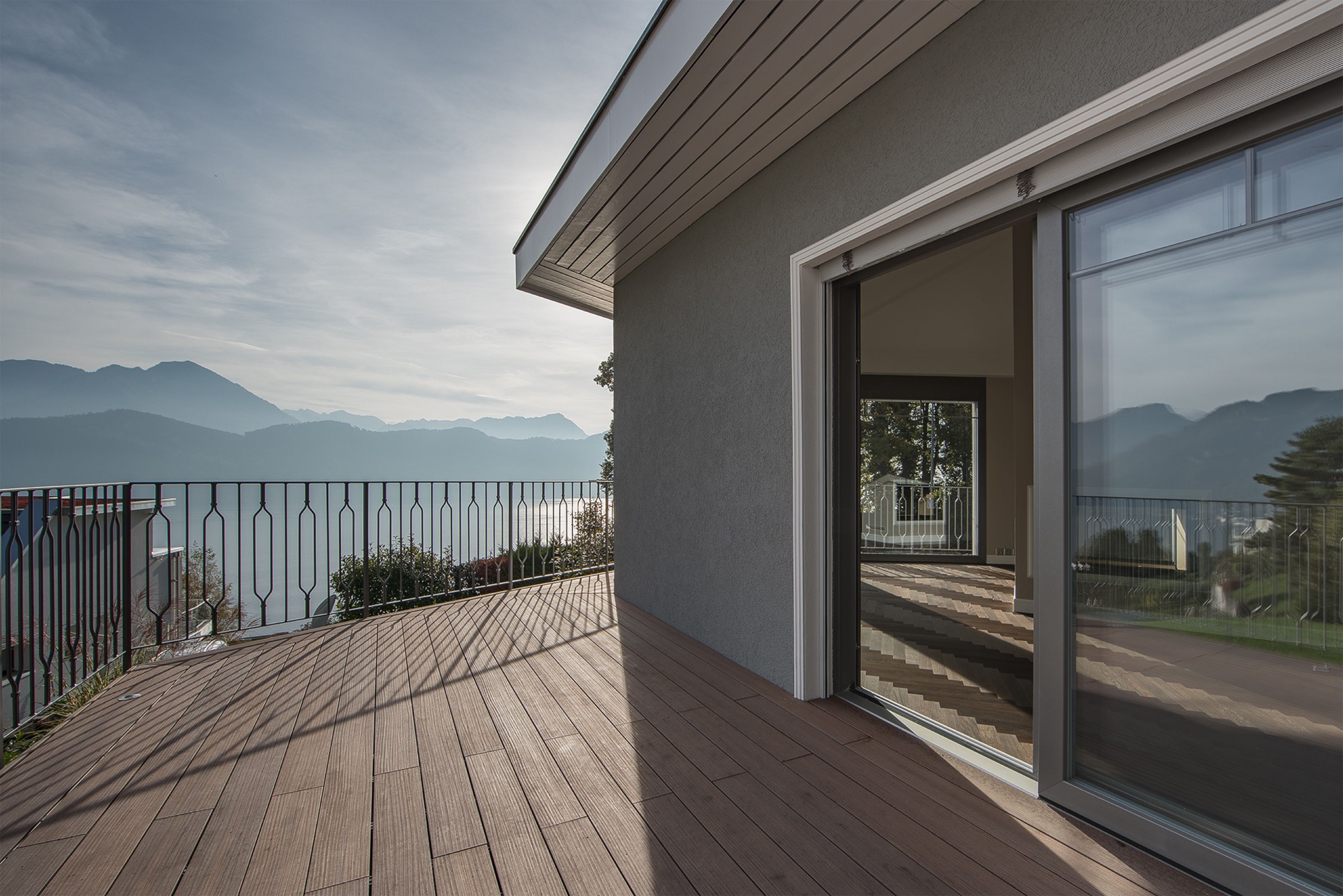 Terrasse mit Holzrost und Blick auf See und Berge